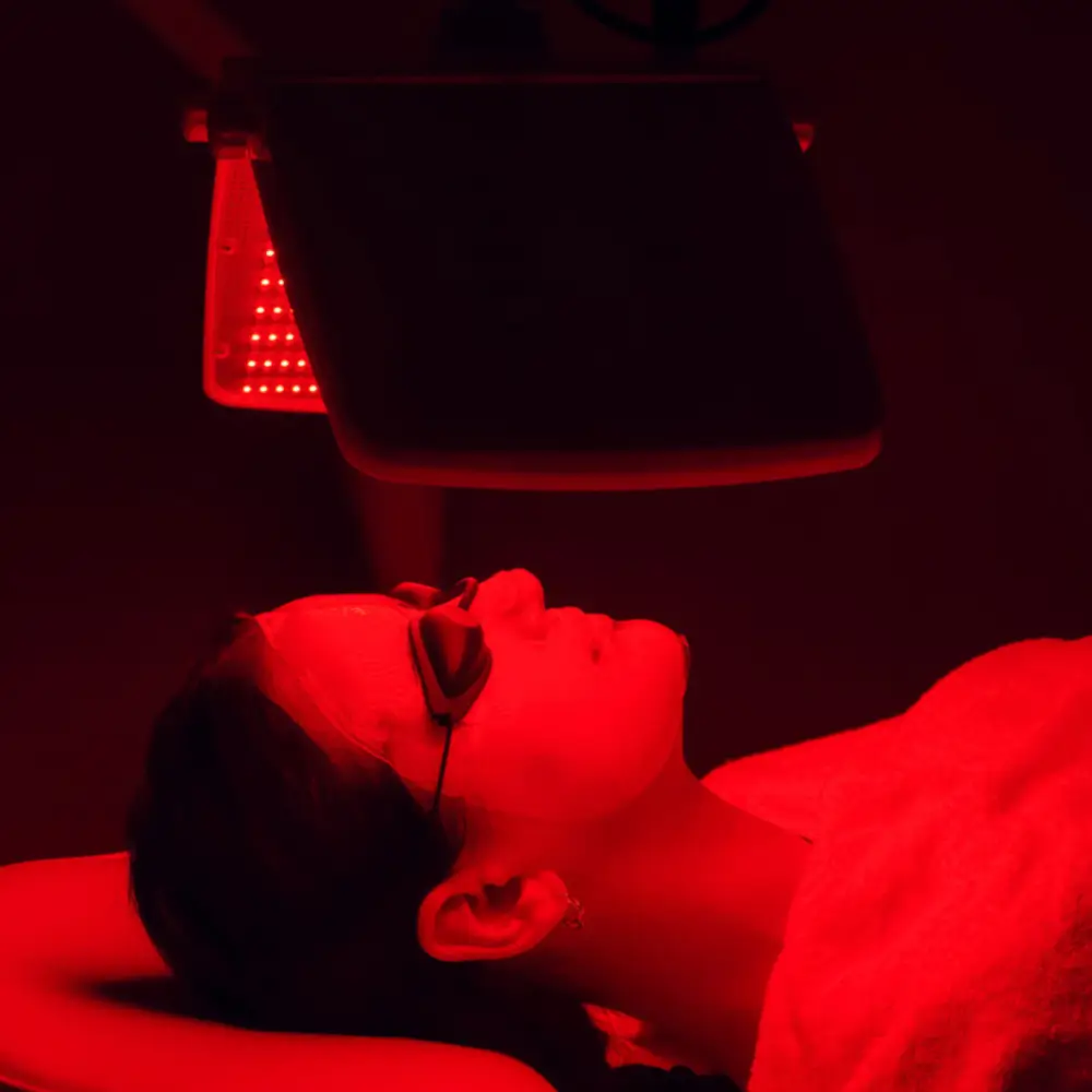 led light therapy for mature skin los gatos woman under red light panel with protective glasses