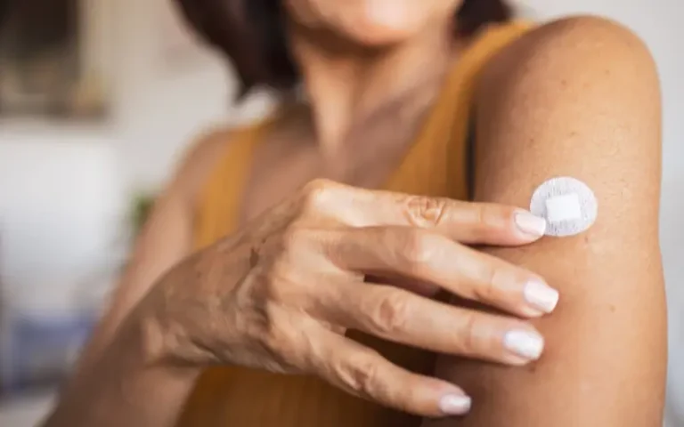 Woman with a hormone patch representing skin changes during menopause and HRT